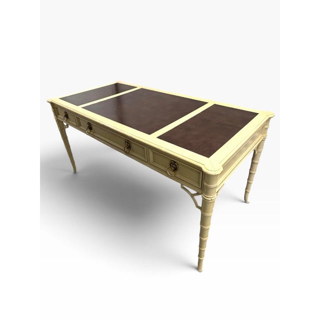 Baker Furniture Chinese Chippendale Regency influenced faux bamboo desk featuring three dovetailed drawers, brass lion...