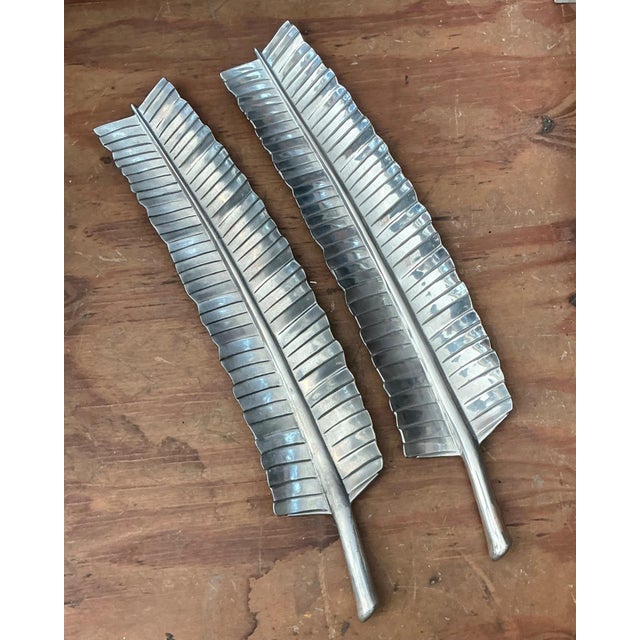 This striking set of two vintage aluminum banana leaf platters exemplifies the refined organic modernism of mid-20th-...
