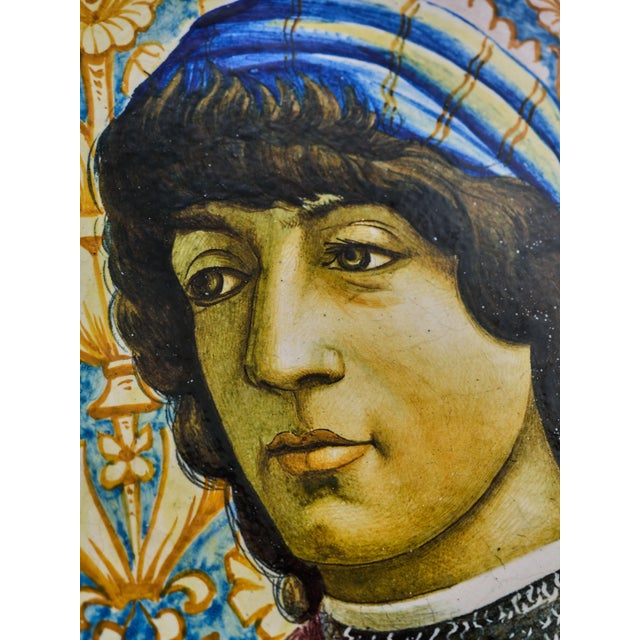 A large, hand-painted Italian platter featuring the portrait of a young man, based on a fresco from the workshop of Sandro...
