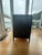 A striking industrial-style cabinet with a hand-riveted iron frame, glass front doors, and glass side panels that let...