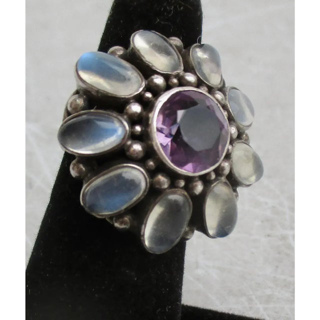 Silver cocktail ring with faceted Amethyst and moonstone settings. Cocktail ring with a deep amethyst center stone and...