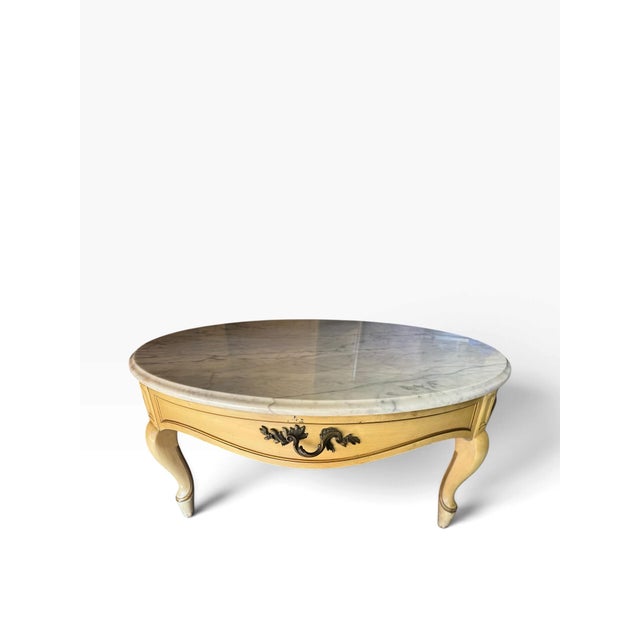 A substantial, 40-inch vintage coffee table by Weiman, featuring a beautifully veined, heavy white-and-gray marble top...
