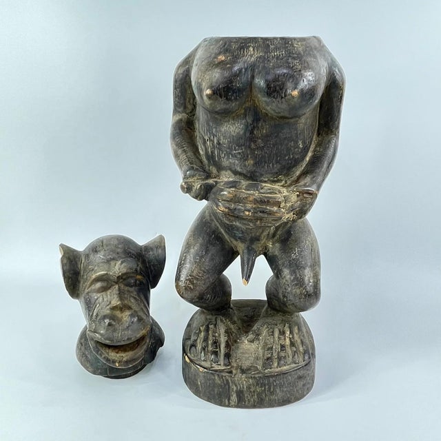 This carved wooden monkey-shaped vessel originates from the Baule people of West Africa. The container is surmounted by a...