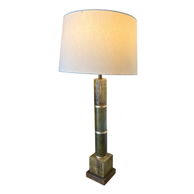 A striking, Hollywood Regency-style, heavy table lamp featuring a jade column in warm cream and deep green tones, joined...