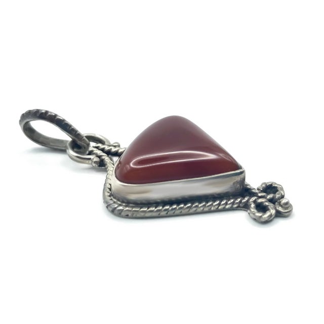 Earthy red carnelian gemstone set in sterling silver with beautiful detailing. A combination of intricate metal work...