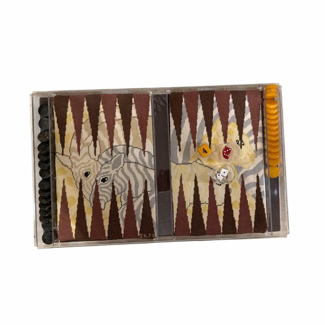 Vintage backgammon set featuring hand-stitched needlepoint playing surfaces with a stylized zebra motif, housed in a clear...