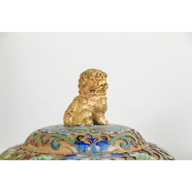 A pair of Chinese enamel covered ginger jars topped with a gilt bronze Buddhist lion finial and richly decorated with...