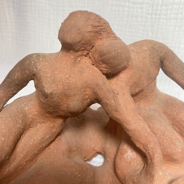 This expressive, hand-modeled raw terracotta studio sculpture depicts two stylized figures in an intimate, organic...