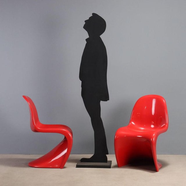 Pair of chairs designed by Verner Panton for a Vitra production in the 1970s, made of red plastic, bearing the brand. This...