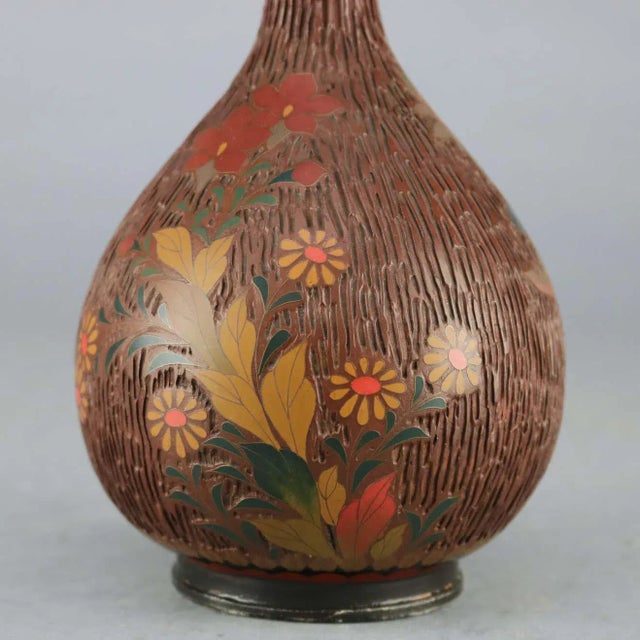 An antique Chinese Aesthetic Cloisonne bud vase offers enameled metal construction all-over textured wood bark design with...