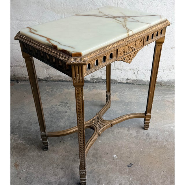 Louis XVI Style gilded Table with Onyx Top inset into the wood frame. This exceptional antique table blends robust...