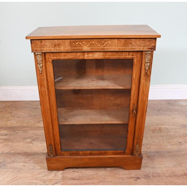 Useful sized Victorian pier cabinet in burr walnut with inlays and ormolu fittings Circa 1880 Glass fronted door opens up...