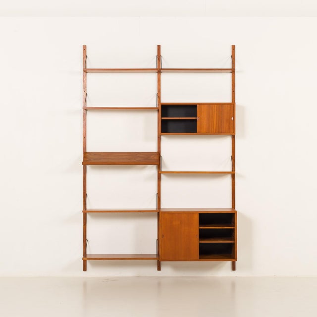 This extra-high teak wall unit with an expository shelf was designed by poul cadovius for cado in the 1960s. Its simple...
