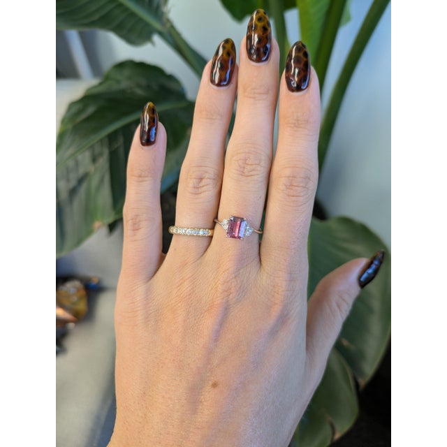 A 1.78-carat emerald-cut bi-color tourmaline blends soft pink and purple in a single natural stone at the centre of this...