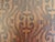 A substantial rectangular ottoman upholstered in richly embossed leather, mid-20th century. The warm brown leather...