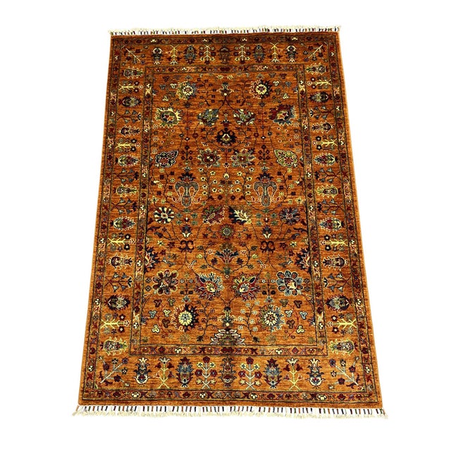 This Sultani Chobi style wool rug features a warm rust field with an allover Persian-inspired floral pattern. Branching...