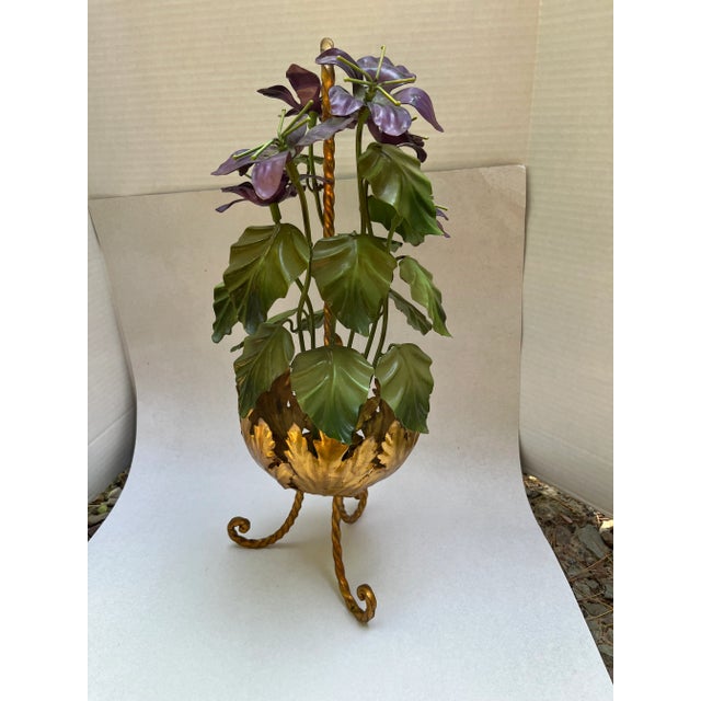 Vintage Italian tole flower sculpture in a stylized footed pot with twisted metal handle. Paint decorated and gold gilt...