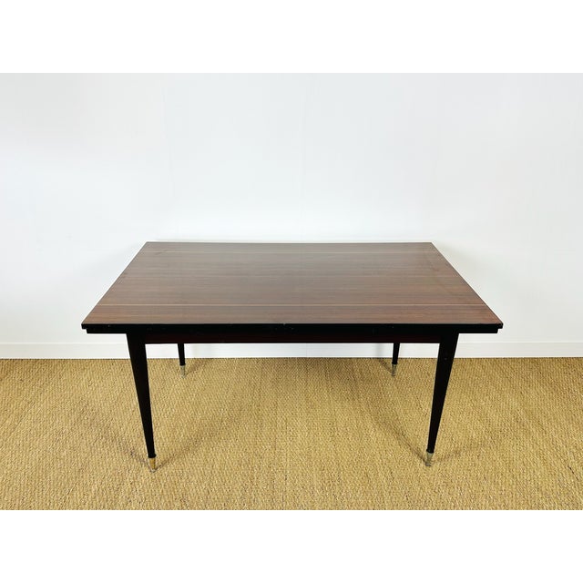 A french art deco dining table dating from the 1960s, featuring two extension leaves. this elegant extendable table,...