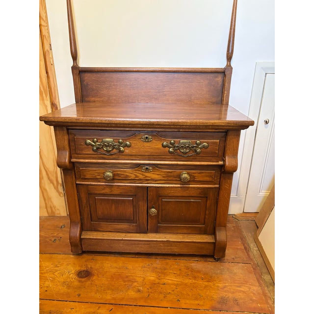 Oak commode early American 20th century with detachable towel rack (can be attached but not for shipping) and brass hardware.