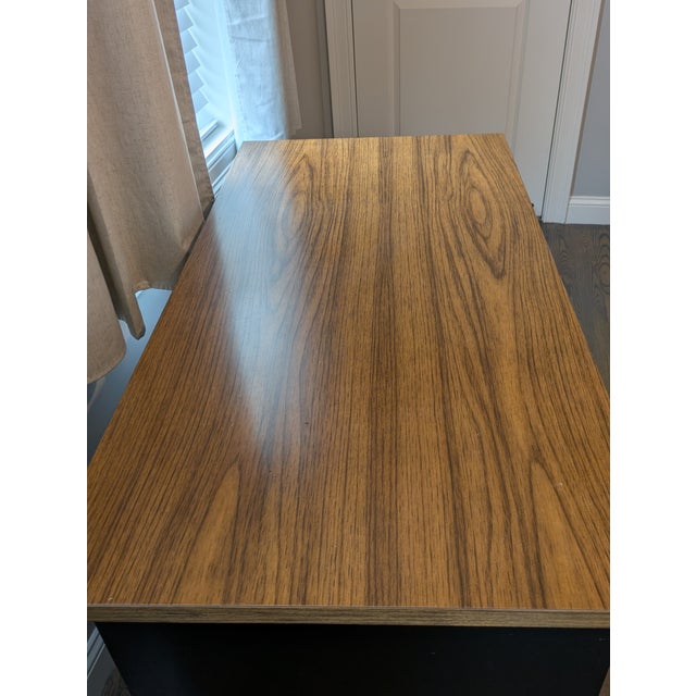 Vintage 1960s mid-century modern solid wood desk with laminate top and brass hardware. The desk provides plenty of storage...