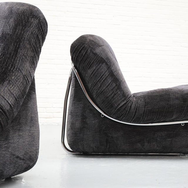Beautiful Italian armchairs from the 1970s featuring an elegant tubular frame and smooth curves. The gray/black upholstery...