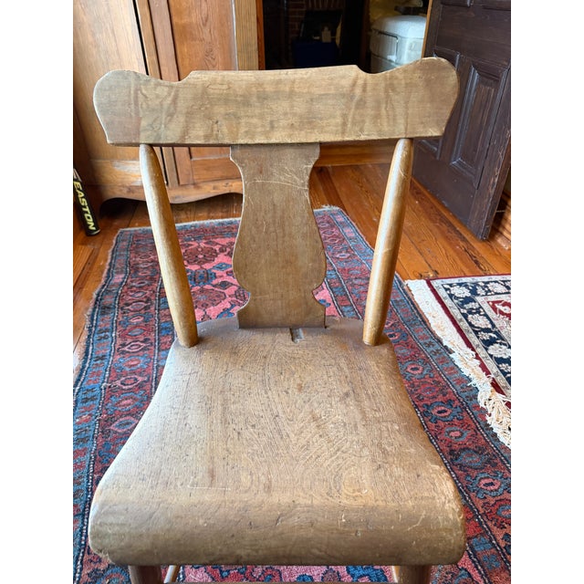 Pair of antique primitive wooden farmhouse chairs with plank seat, turned legs, and shaped crest rail with central splat....