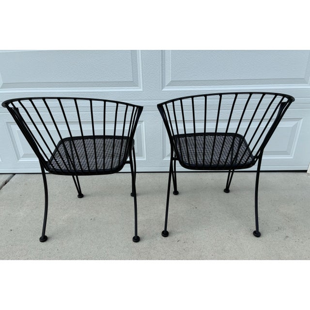 A vintage 1950s wrought iron garden chairs set of two by Woodard. 'Pinecrest' was one of their most charming designs in...