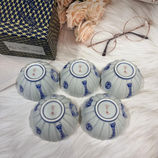 A set of Japanese blue-and-white small bowls, shaped like chrysanthemum petals and featuring delicate, elegant blue-and-...