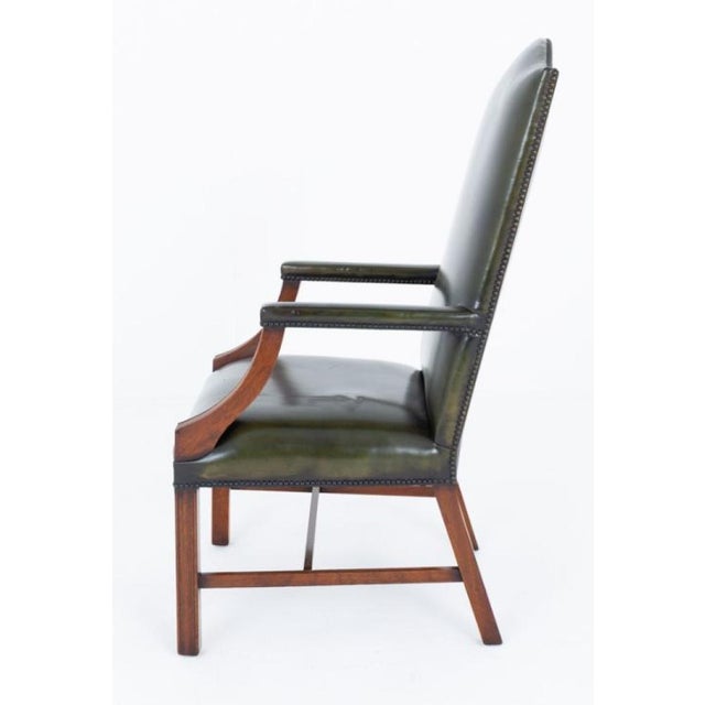 A handsome pair of Georgian Revival Gainsborough armchairs of generous proportions, raised on square fluted front legs...