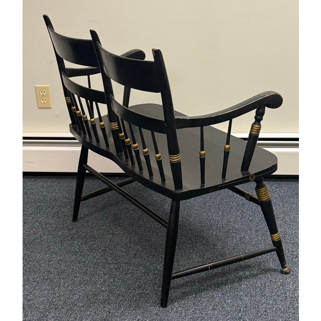 Charming vintage Hitchcock-style painted settee featuring a classic black finish accented with hand-painted gold...