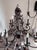 A dramatic large two-tier wrought iron chandelier with 12 candle-style light positions, ornate scrollwork throughout, and...
