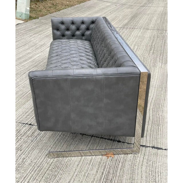 A Milo Baughman style, cantilevered sofa with tufted faux leather and chrome frame.