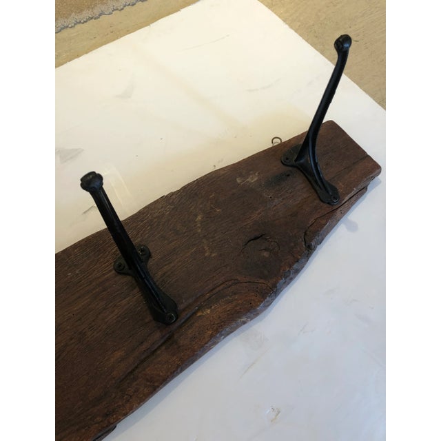 A functional and rustic antique hanging wall coat hanger made from a live edge hunk of impressive wood and having...