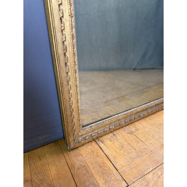 Important Louis XVI giltwood mirror. Ribbon decoration. The mercury mirror is in two parts. Paneled back.