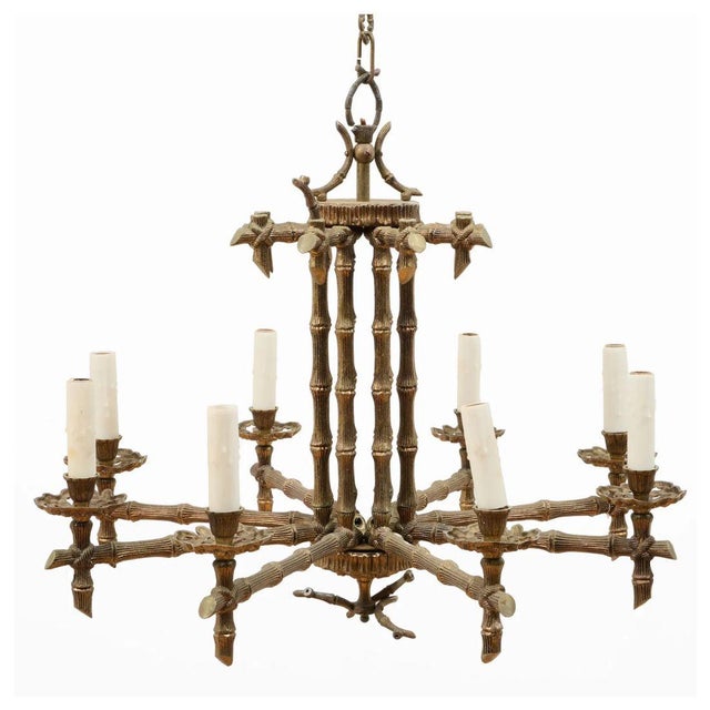 A vintage Hollywood Regency style eight light chandelier in bronze faux bamboo form. The chandelier features eight...