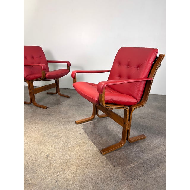 Authentic pair red leather/ rosewood framed “Siesta arm chairs” by Norwegian designer Ingmar Relling for Westnofa. Comfort...