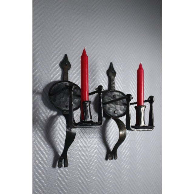 Pair of hand forged wrought iron candle sconces made during the XXth century in France. They are designed after sconces...