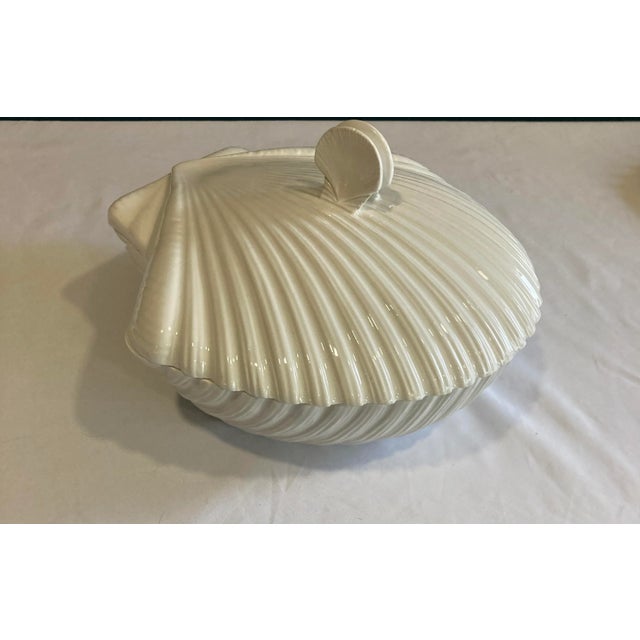 Made in Italy, this stunning covered ceramic dish features a sculpted shell motif and a unique handle formed by two small...