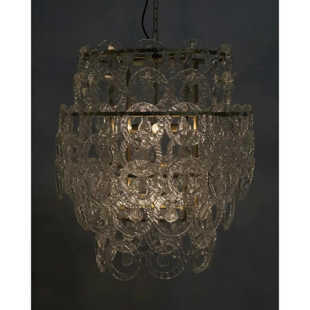 A classic crystal chandelier is updated here, with sleek glass, an antiqued brass finish, and elegantly ornate lines.