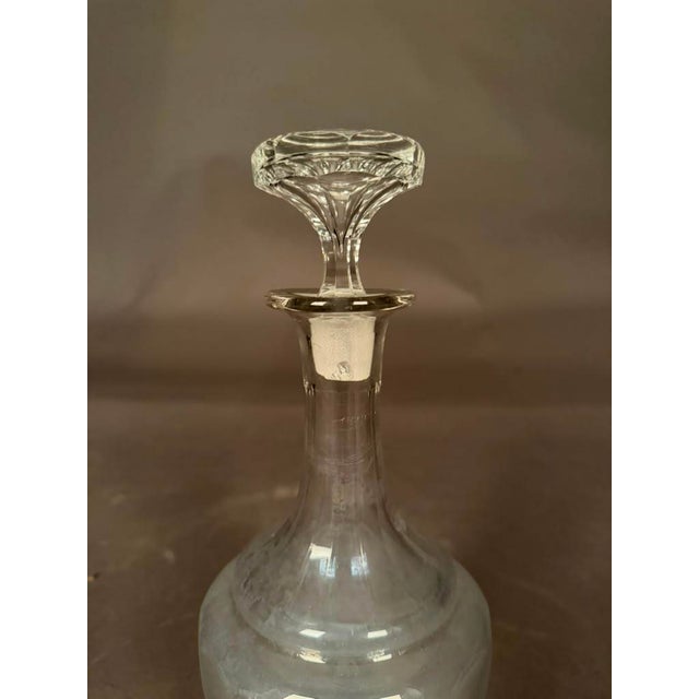 Elegant English cut glass decanting bottle dating to the circa 1920s, featuring a decorative cut-glass design and fitted...