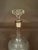 Elegant English cut glass decanting bottle dating to the circa 1920s, featuring a decorative cut-glass design and fitted...