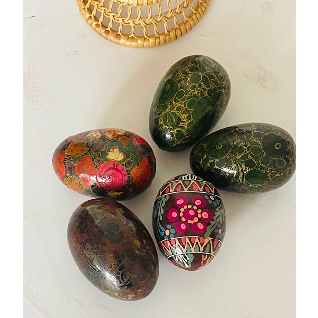 5 Handpainted wooden Plates aster eggs in a small wicker basket.