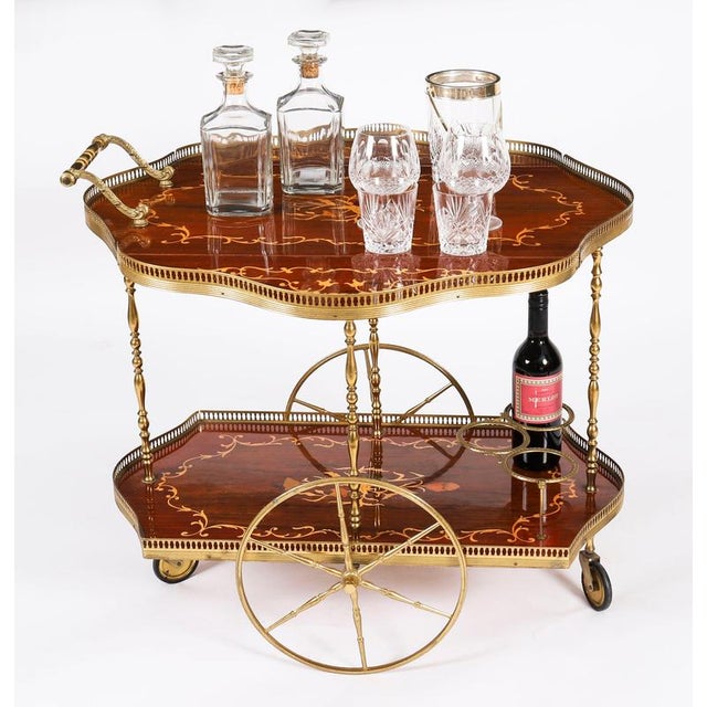This is a very entertaining vintage two tier Italian Sorrento drop-leaf drinks trolley, mid century in date. The shaped...