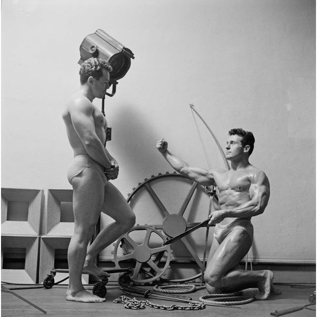 Muscle Men American fitness expert Jack LaLanne (1914 - 2011, right) holding a gladiator's sword during a photoshoot,...