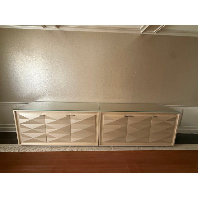 A dramatic pair of custom identical contemporary buffets finished in a warm champagne tone and topped with thick...