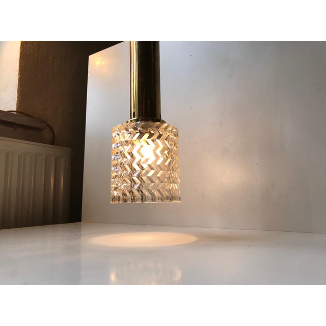 This Hand-grenade shaped Pendant was manufactured by Orrefors in Sweden during the 1960s. It features a geometrically cut...