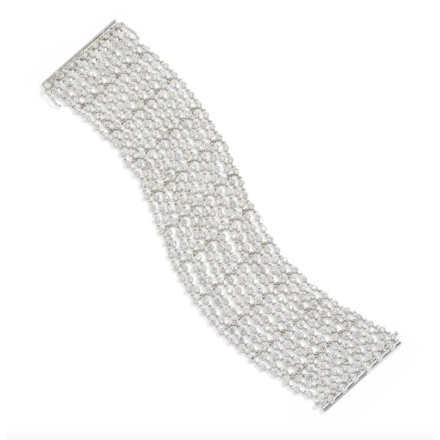This finely crafted bracelet moves like fabric and contains numerous bright bezel set round brilliant cut diamonds...