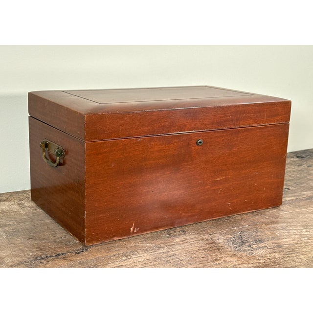 This vintage Benson & Hedges cigar humidor, c.1920's, is crafted in a richly finished wooden case with brass hardware and...