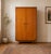 A stylish 1960s Uniflex wardrobe in beautifully figured teak veneer, featuring recessed circular handles and tapered legs....