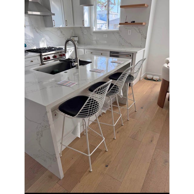 Brand new - 3 white wire base Eames Herman Miller stools, still with tags, black leather pads.
